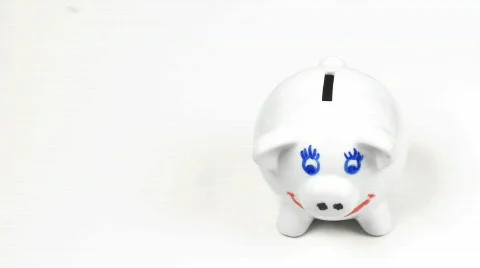 Hand putting money in a piggy bank. Concept of saving money Stock Footage