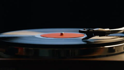 Hand putting needle vinyl playing music on retro turntable in dark room closeup. Stock Footage 332616890