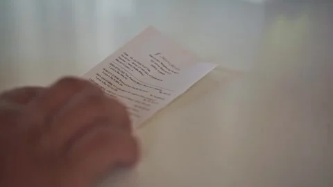 Hand putting payment receipt on to the table, reviewing purchase details, Video stock 344012217