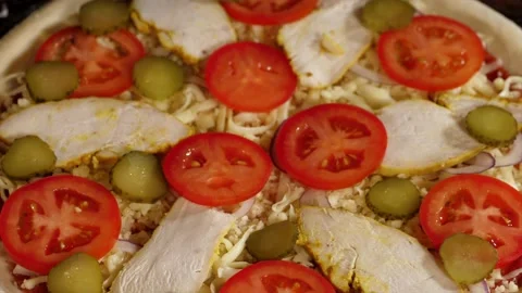 The hand is putting pickled cucumbers on pizza, close-up Stock Footage 144311330
