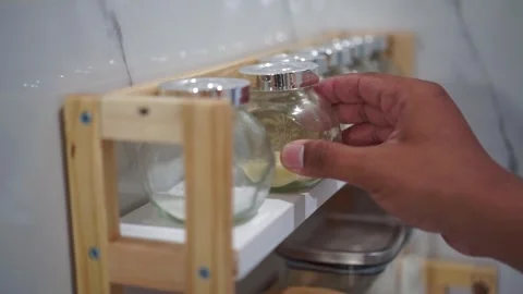 Hand putting powdered stock container back on shelf close up, kitchen Video stock 344011979