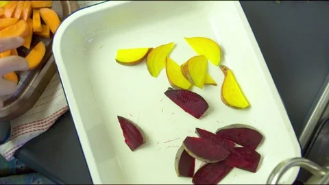 Hand putting pumpkin and beetroot slices in tray Stock Footage 76133496