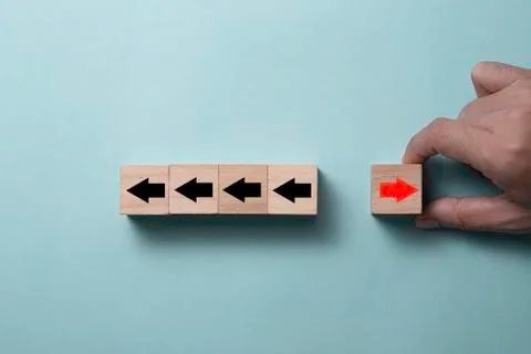 Hand putting putting cubes block for change direction of red arrow from left Stock Photos