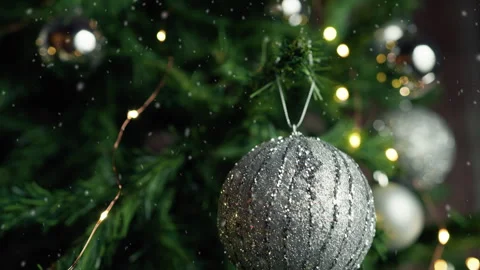 Hand putting a silver ball as decoration on a Christmas tree Stock Footage 254178437