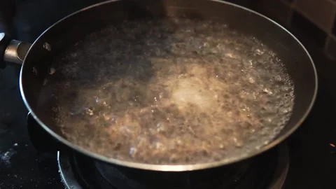 Hand putting small slices of green broccoli into a boiling water in a pan. Stock Footage 134939269