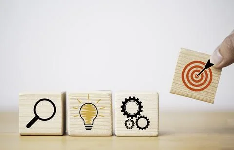 Hand putting target board which printing on wooden cube block on mechanical.. Stock Photos
