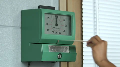 Hand putting time card in punch clock and clocking in Stock Footage