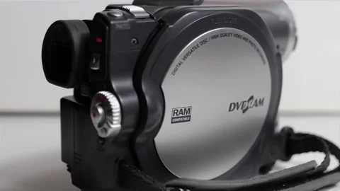 A hand putting a vintage mini DVD in a 2001 Hitachi DVD camcorder Stock Footage 164410171