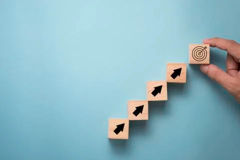 Hand putting virtual target board and arrow which print screen on wooden cube Stock Photos