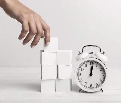 Hand putting white cubes clock Stockfoto's