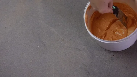 Hand with a putty knifeapplies paste to a hole in the concrete. Top view Stock Footage 124070496