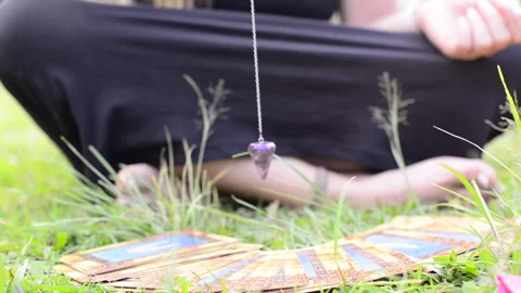 Hand of pythoness girl uses pendulum. Spiritual mediumship. Dowsing oracle Stock Footage 260813487
