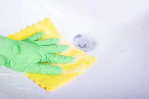 Hand with a rag cleans the sink in the bathroom Stock Photos