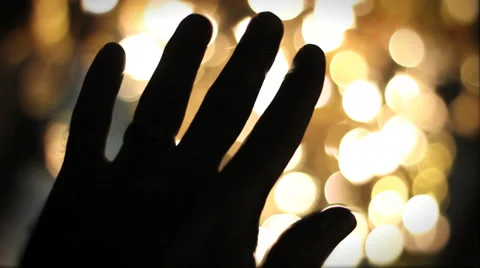 Hand raised with bokeh lights in the background Stock Footage 35538688