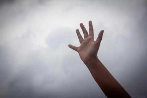 Hand raised high with sky in background Foto stock