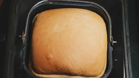 Hand raises black lid of automatic bread machine with ready-made loaf of fresh Stock Footage 196268933