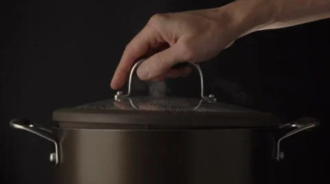 Hand raising lid on steaming pot Stock Footage 61802292