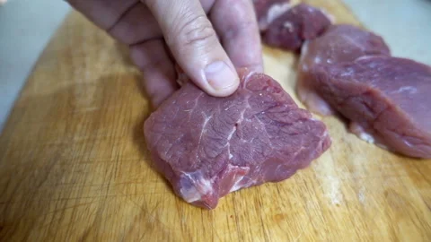Hand with raw meat slice and spices in slow motion. Stock-Footage 135736207