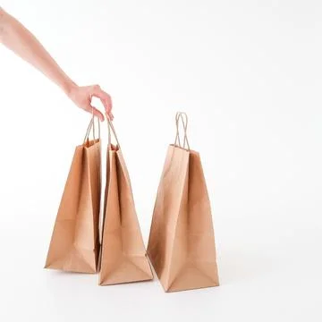 The hand reaches for a craft bag on a white background. Space for text and .. Stock Photos
