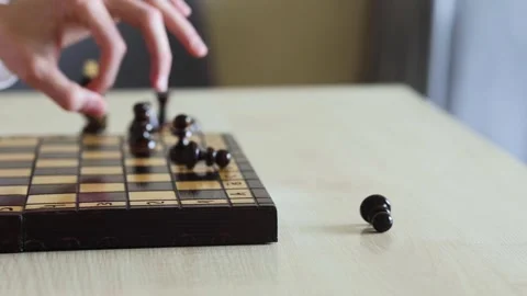A hand reaches down to move a chess piece on a board Stock Footage 278900589