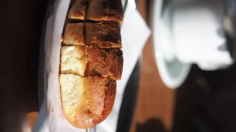 Hand reaches for fresh sliced bread in basket, close up shot, preparing meal. Stock Footage 332034691