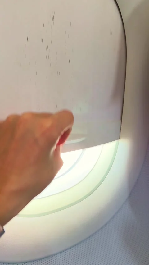 A hand reaches out and opens the airplane window Stock Footage 327386202