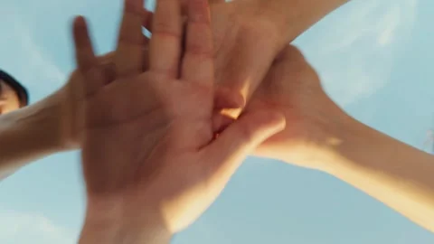 A hand reaches out to join a team of people. Another hand joins, and the group Stock Footage 293672871
