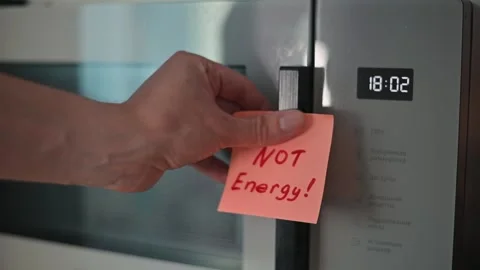 A hand reaches to place a sticky note on a refrigerator door, signaling a Stock Footage 339096668