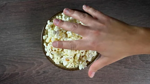 Hand reaches for popcorn Stock Footage 139387579