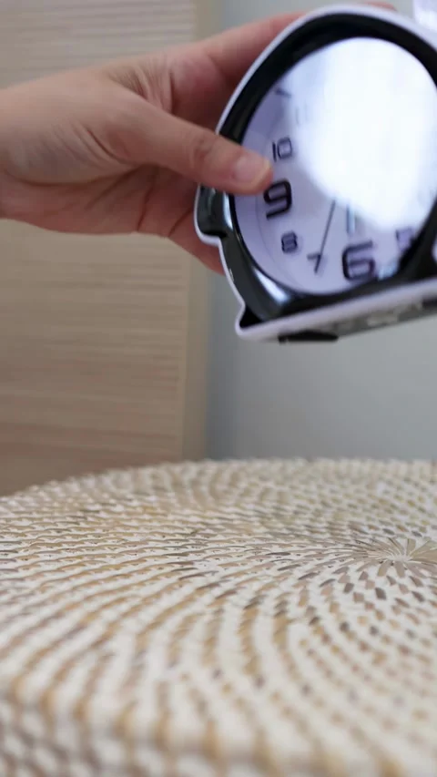 Hand Reaching for Alarm Clock on Bedside Table in Morning Stock Footage 333604932