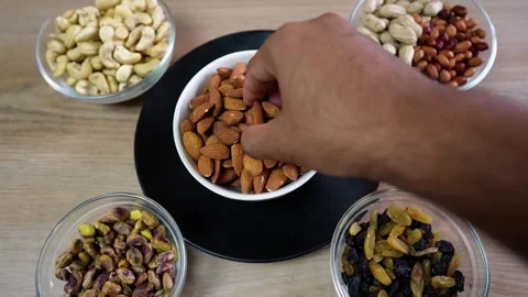 Hand Reaching for Almonds in a Nut and Fruit Assortment Stock Footage 320726908