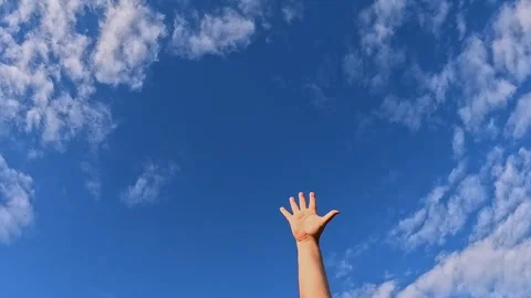 Hand reaching up to blue sky with clouds, freedom and hope Video stock 323975773
