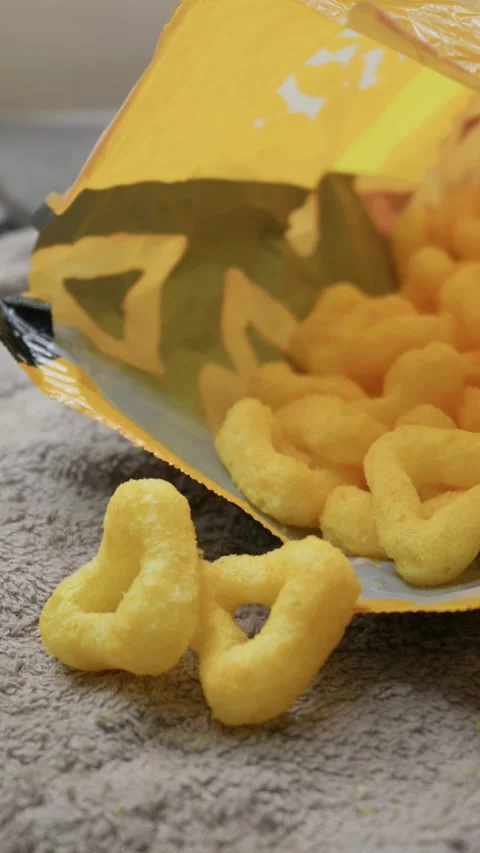 Hand Reaching for a Crunchy Cheese Puff Snack from Open Yellow Bag Stock Footage 341996060