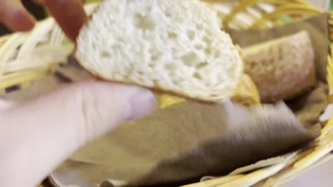 Hand Reaching for Crusty Bread Slices in a Basket Stock Footage 343884640