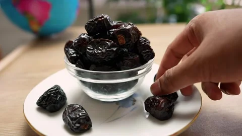 Hand Reaching for a Date from a Bowl Stock Footage 320727866