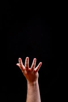 Hand Reaching Up in Dramatic Light on a Black Background Stock Photos
