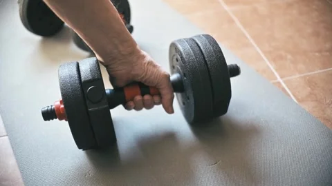 Hand Reaching for Dumbbell on Exercise Mat in Home Gym Setting for Training Vídeos de archivo 331901782