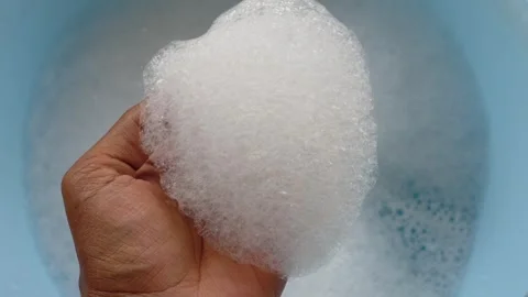 Hand reaching into frothy bubbles in a comfortable bath setting Stock Footage 307992103