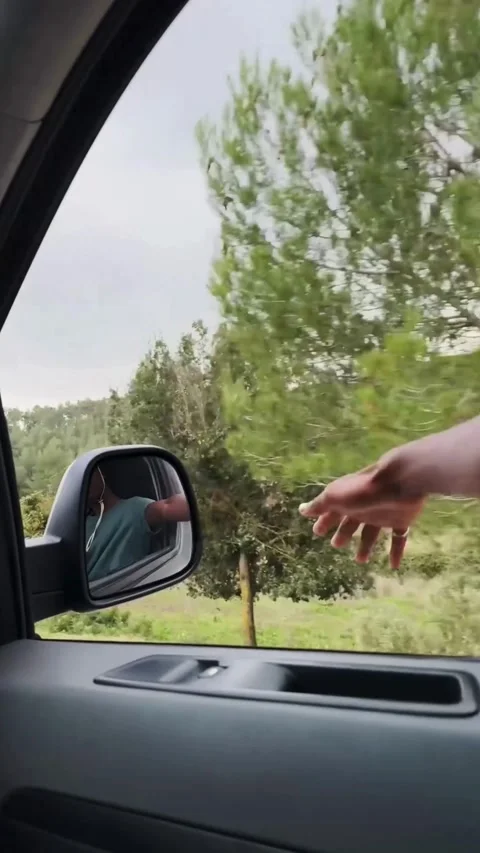 Hand reaching out of car window during road trip Stock Footage 331778894