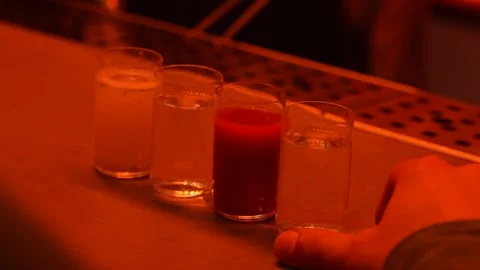 Hand Reaching for Shots of Different Cocktails on Bar Stock Footage 318002004