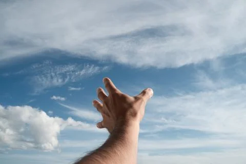 A hand reaching into the sky. Point of view. Sunlight. Stock Photos