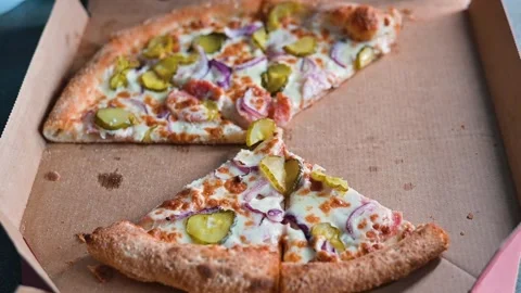 A hand is reaching for a slice of pizza from a takeout box, leaving behind only Stock Footage 338290106