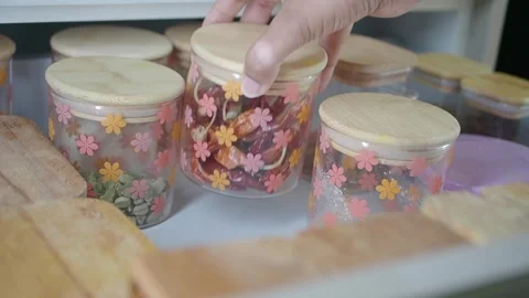 Hand reaching for spice jars in a kitchen setting at home Stock Footage 345385725