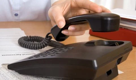 Hand reaching for telephone Stock-Fotos