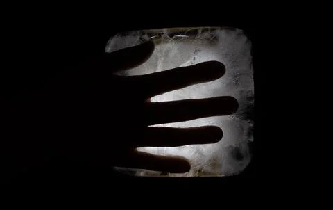 A Hand Reaching Through A Rectangular Opening In Darkness Stock Photos