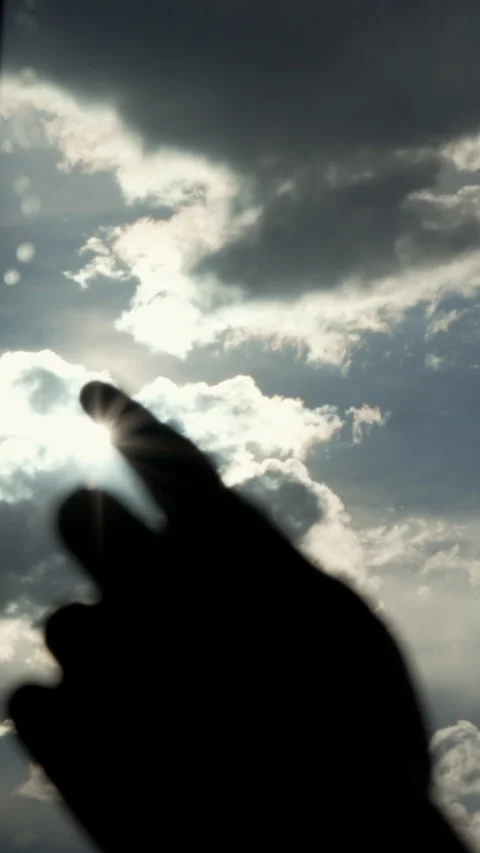 Hand Reaching Toward Sunlight Behind Clouds – Concept of UV Exposure Stock Footage 318424029