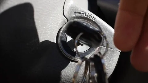 Hand reaching in to turn car key starting the car Video stock 76686890