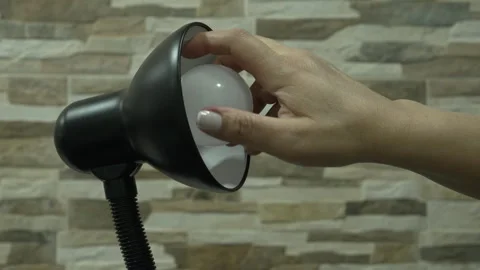Hand Reaching to Turn Off LED Bulb in Black Desk Lamp Stock Footage 341059157