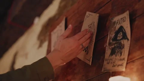 Hand Reaching for Wanted Poster in Dimly Lit Medieval Tavern featuring posters Vidéo 347081962