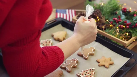 Hand red decorating gingerbread biscuits white icing sugar glaze winter holidays Stock Footage 165864622